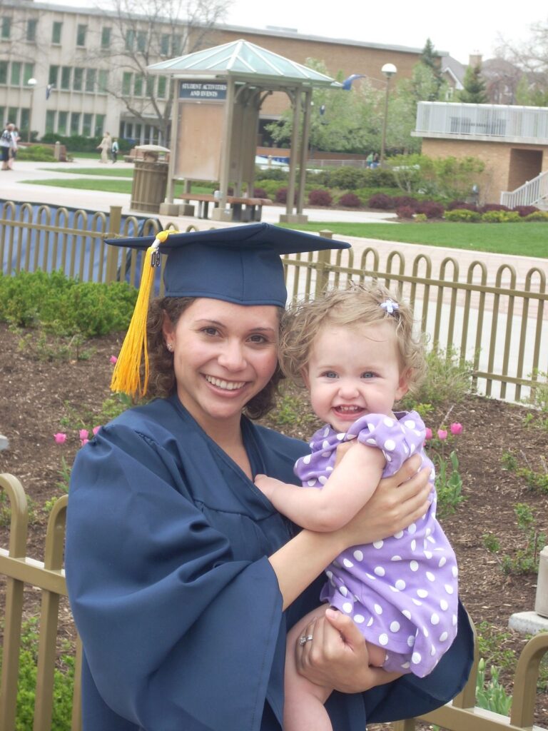 Woman graduating holding a baby